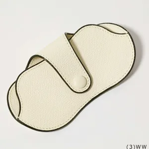 Detail view of portable PU leather glasses case with snap button and contrast black piping.