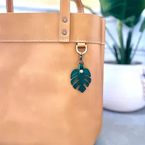 Green monstera leaf PU leather bag charm, stylish chic keychain pendant for purses keys.