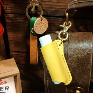 Retro lederen lippenbalsem hoes etui met sleutelhanger, draagbare lippenstift beschermer detail.