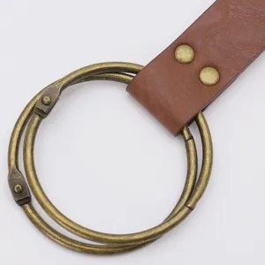 Detail shot of medieval PU leather belt with antique brass double rings and metal rivet accents.
