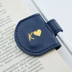 Close-up detail of a dark blue PU leather magnetic bookmark with gold foil letter K and heart.