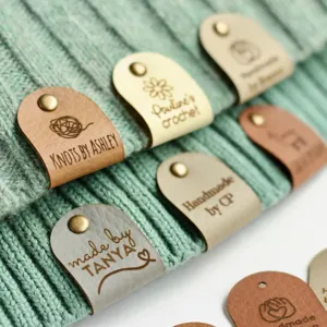 Custom PU leather tags with metal rivets for handmade knitting and crochet projects.