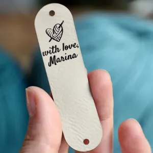 Handmade leather label with crochet heart design, ideal for DIY knitting and crafting projects.