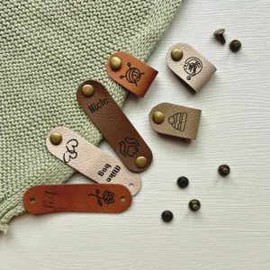 Custom PU leather labels with rivets for handmade knitting crochet DIY craft projects detail view.
