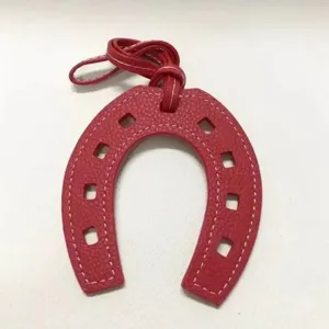 Fashion red leather horseshoe bag charm, creative U-shaped pendant for handbags and purses.