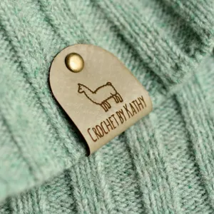 Custom handmade crochet leather tags with rivets for knitted items, DIY personalized labels.
