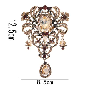 Vintage rhinestone hollow flower brooch with crystal pendant, elegant coat accessory.