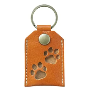 Cute PU leather pet hair storage keychain with hollow paw print design, ideal souvenir bag.