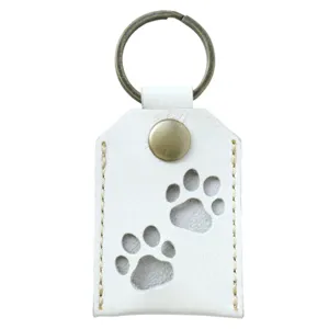 Detailed view of white PU leather pet memorial hair storage keychain with paw prints.