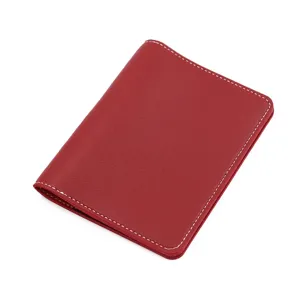 Red PU leather passport holder detail view showing neat white stitching and fine texture.