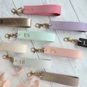 Customized PU leather wristlet keychain with gold initial letters, stylish portable car key ring.