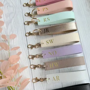 Detailed view of personalized PU leather wristlet keychains with custom monogram letters.