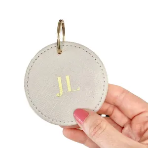 Personalized PU leather round keychain with gold custom initials, stylish minimalist keyring.
