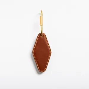 Detailed view of brown PU leather diamond keychain with brass tone metal hardware clasp.