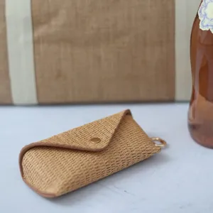 Close-up detail of straw woven glasses storage pouch, portable minimalist design for sunglasses.