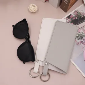 Detail view of portable PU leather glasses pouch with spring ring and classic sunglasses set.