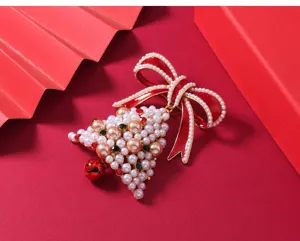 Close-up of Christmas pearl bell brooch with red bow and rhinestones detail shot.