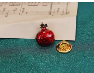 Red enamel pomegranate brooch close up detail showing red glazed texture and metal clutch.