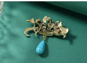 Vintage Chinese style metal brooch pin with turquoise teardrop pendant for women dress apparel.