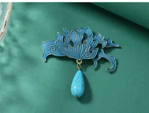 Close-up of exquisite Chinese style enamel flower brooch with teardrop turquoise pendant.