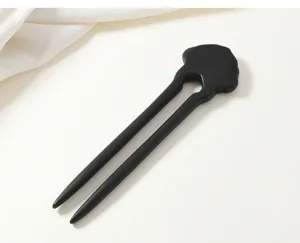 Detailed close-up of a black wooden hairpin with ruyi carving, perfect for Chinese style hair.