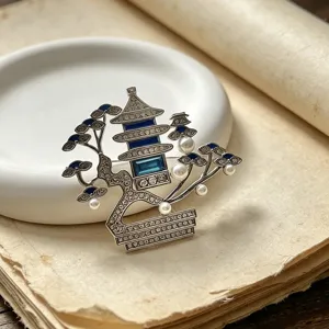 Exquisite detail shot of a Chinese style pagoda brooch with pearls and blue rhinestones.