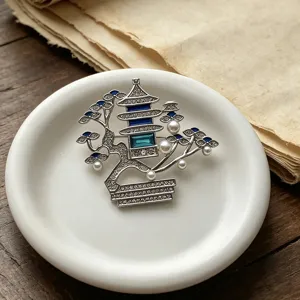 Detailed shot of Chinese style pavilion brooch with pearls and blue rhinestones.