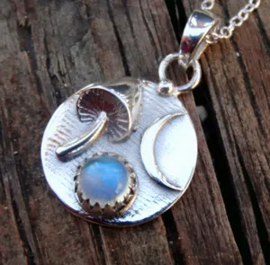 Silver mushroom and moonstone crescent pendant detail close up shot showing fine texture.