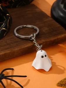 Close-up of a cute white ghost keychain with metal ring, Halloween spooky style pendant detail.