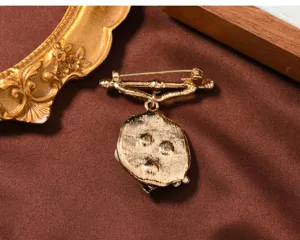 Detailansicht der goldenen Vintage Brosche mit feiner und eleganter Metallarbeit.