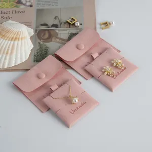 Detail shot of pink suede jewelry storage pouch with snap button, perfect for rings and earrings.
