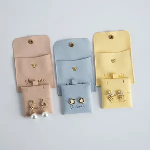 Closeup detail of soft velvet jewelry pouches with snap buttons and delicate earring display cards.