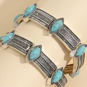 Close-up of bohemian style vintage silver alloy cuff bracelets inlaid with turquoise stones.