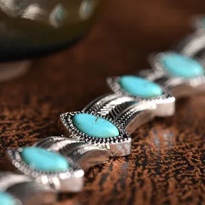 Detailed close-up of vintage bohemian turquoise alloy necklace, intricate retro carved metal.