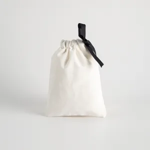 Detailansicht eines minimalistischen weissen Baumwollkordelzugsbeutels mit schwarzem Band.