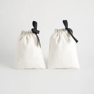 Kleine Baumwoll-Leinen-Kordelzug-Geschenktüten mit schwarzem Band für Schmuckaufbewahrung.