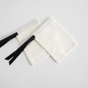 Detailaufnahme des weißen Baumwollbeutels mit edlem schwarzen Band als Kordelzug.