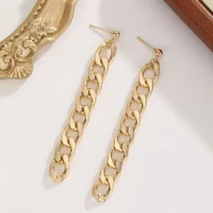 Close-up detail of stylish gold chunky chain drop earrings with a sleek metallic finish.
