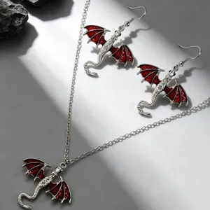 Detailed shot of silver dragon necklace and earrings set featuring striking red wing accents.