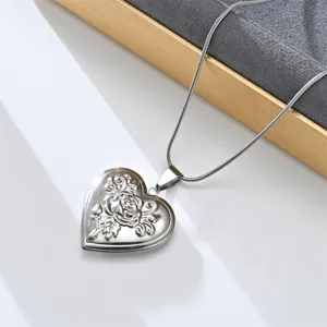 Stainless steel heart locket necklace detail, vintage rose pendant close up view.