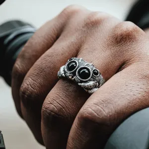 Gros plan d'une jolie bague araignée sauteuse avec des yeux en cristal noir et finition argent.