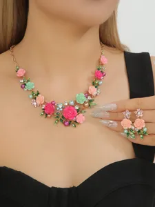 Close-up detail shot of the elegant enamel camellia floral necklace and matching earrings set.