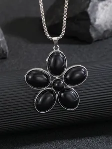 Primo piano dettagliato di una collana d'argento con ciondolo a fiore nero a cinque petali.