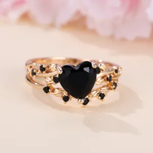 Anello cuore nero placcato oro con zirconi scintillanti e delicato design a vite.
