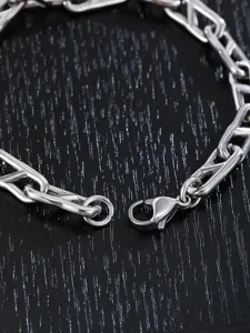 Primo piano dettaglio della chiusura del bracciale catena argento, gioiello uomo.