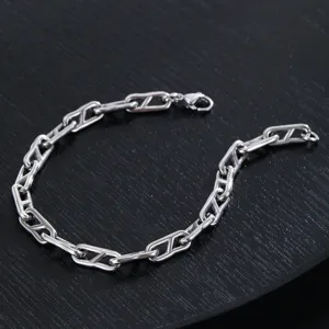 Dettaglio del bracciale a catena in metallo argentato da uomo con classico design a maglie.