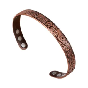 Vintage copper magnetic bracelet with embossed floral pattern, adjustable open bangle jewelry.