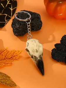 Detailed shot of gothic bird skull keychain pendant with metal ring for Halloween decor.