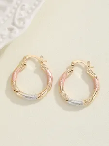 Gedetailleerde opname van driekleurige gedraaide creolen, geometrische sieraden