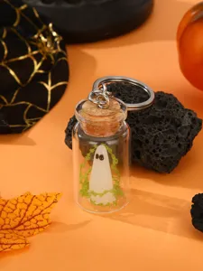 Halloween ghost keychain detail, glowing resin figure in glass bottle with cork stopper.